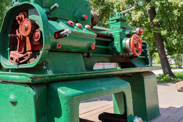 Old vintage green boring lathe on display at a city holiday in the park