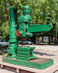 Old vintage green boring lathe on display at a city holiday in the park