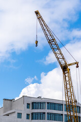 Construction crane on a background of the sky near the new building
