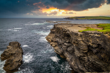 Naklejka premium Rocky cliffs in Kilkee at sunset, County Clare. Ireland.