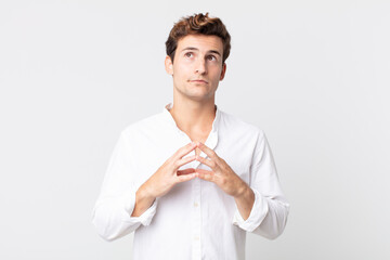 young handsome man scheming and conspiring, thinking devious tricks and cheats, cunning and...