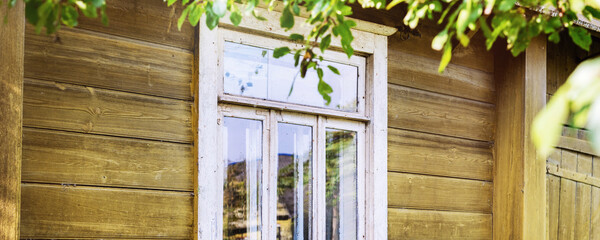 Wooden house painted in yellow colour with white window frame