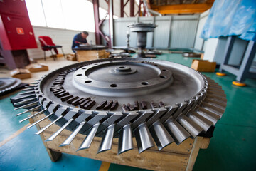 Close-up of turbine rotor (impeller). Changing blades. Service of steam turbines in Kazturboremont (KTR) plant. Man on background blurred