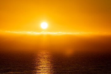 Bright sunset with large yellow sun in Ireland