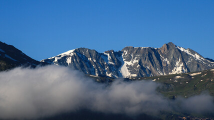 Snow capped rocky peak. View of a mountain range in summer or summer with snow at the top.