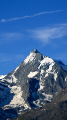 Snow capped rocky peak. View of a mountain range in summer or winter with snow at the top.