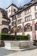 Fototapeta na wymiar The Sevogel fountain on the Martinskirchplatz (Martin Church Square) built in 1400s, at the town certer of Basel, Switzerland
