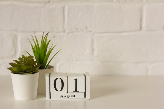 August 1.The 1st day of the month, a wooden perpetual calendar at the workplace. Hello August. Empty space for the text.