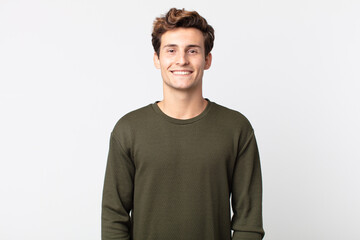 young handsome man smiling cheerfully and casually with a positive, happy, confident and relaxed...