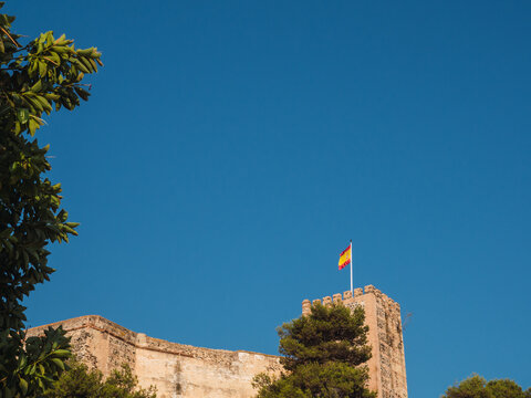 Sohail castle with flag of Spain and blue sky