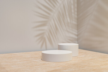 Cosmetic display product stand. Two cylinder podium on wood table and gray background with palm leaf shadow. 3D rendering illustration