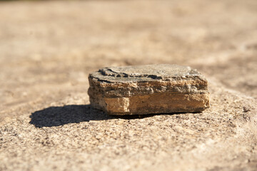Stone podium on a beige background for a natural design concept. Central composition, front view. High quality photo