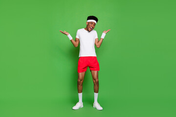 Fototapeta na wymiar Full length photo of funny impressed dark skin man wear white t-shirt rising hands arms open mouth isolated green color background
