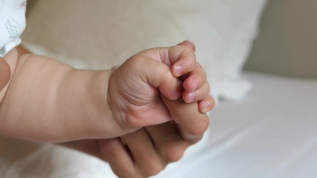 Close up of mothers hand holding babies hand infant childhood
