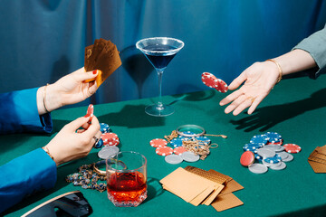 Crop women playing poker at table