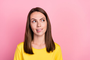 Fototapeta premium Photo of unsure thoughtful young woman dressed yellow t-shirt biting lip looking empty space isolated pink color background