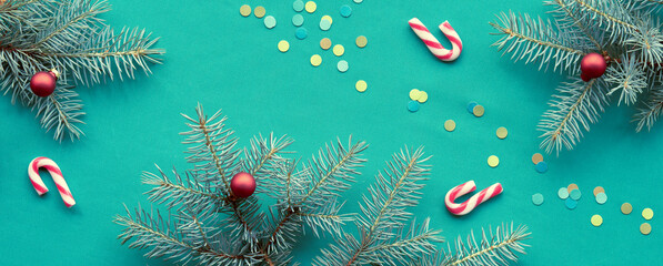 Christmas panoramic banner background. Flat lay, top view with candy canes, confetti and fir twigs...