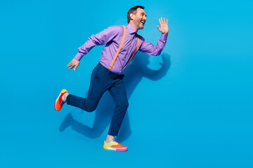 Obraz premium Full size profile side photo of excited mature man happy positive smile go walk run hurry isolated over blue color background