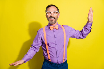 Photo of handsome mature man happy positive smile have fun wear eyeglasses isolated over yellow color background