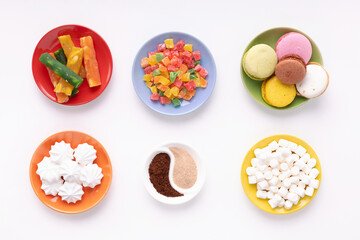 Candied fruits and macaroon in colorful plate at white background