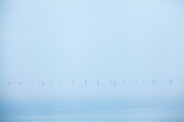 Windfarm at sea in the mist
