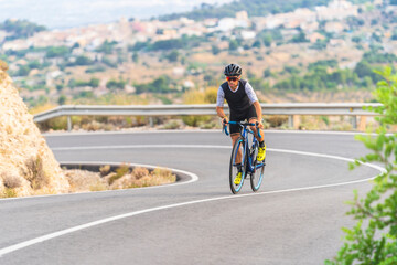 Fototapeta na wymiar Professional cyclist on curvy mountain roads.