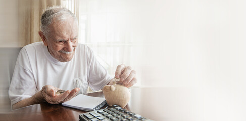happy old man puts the saved money in the piggy bank. savings, old age, business, and the banking...