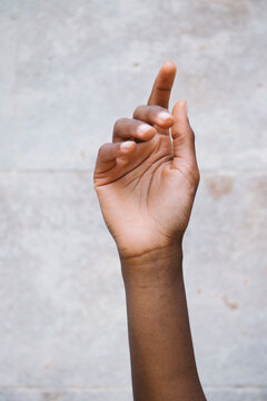 Crop black woman hand against gray wall