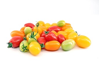 Colorful mini plum tomatoes on white backgrounds . Colors are red, green, yellow and orange