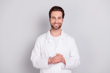 Photo of dreamy cheerful young guy doctor workwear arms together smiling isolated grey color...