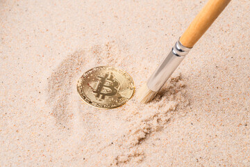 gold bitcoin buried in the sand. cryptocurrency and money