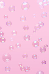Various soap bubbles on a pink background.