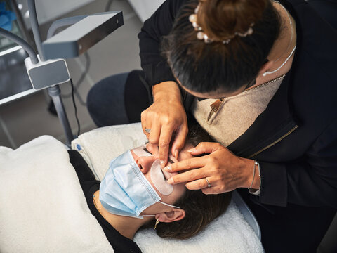 Woman getting eyelash lifting procedure in salon