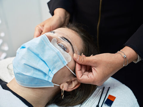 Woman getting eyebrow lamination procedure in salon