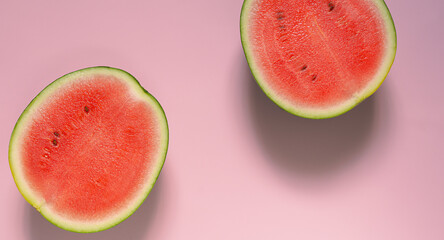 Two half red watermelon on pink background.Top view with copy space.
