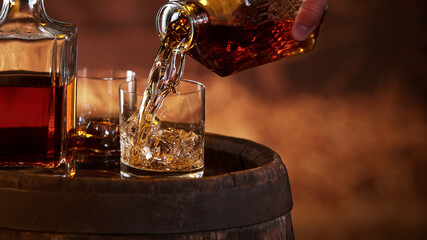 Freeze motion of man hand pouring whisky shot