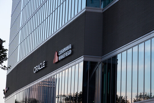 Warsaw, Poland - July 27, 2021: View at Oracle and Cushman and Wakefield logos on the office facade