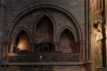 STRASBOURG, FRANCE, June 23, 2021 : In Strasbourg Cathedral a sculpture of a wearing hat head of an architect gazes from the balustrade at the pillar of angels.