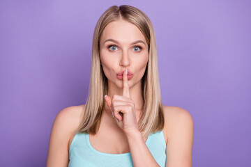 Photo of serious blond young lady finger mouth wear blue top isolated on violet color background