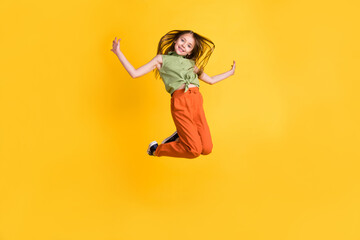 Fototapeta na wymiar Full length body size photo little girl jumping up careless happy isolated vibrant yellow color background