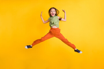 Full length photo of funky blond small girl jump wear top trousers isolated on yellow color background