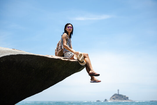 Beautiful Asian girl enjoying the seaside in sunny summer's day