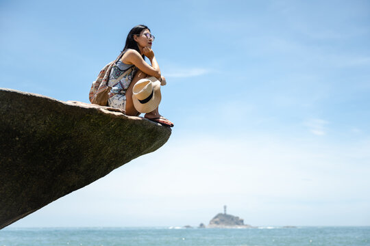 Beautiful Asian girl enjoying the seaside in sunny summer's day
