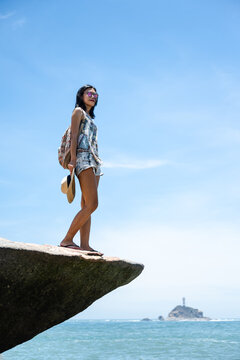 Beautiful Asian girl enjoying the seaside in sunny summer's day