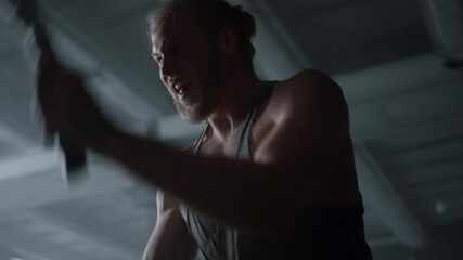 Sportsman working with battle ropes. Fitness man having intensity training