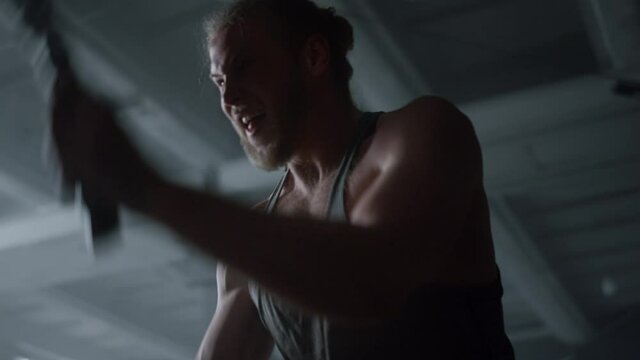 Sportsman working with battle ropes. Fitness man having intensity training