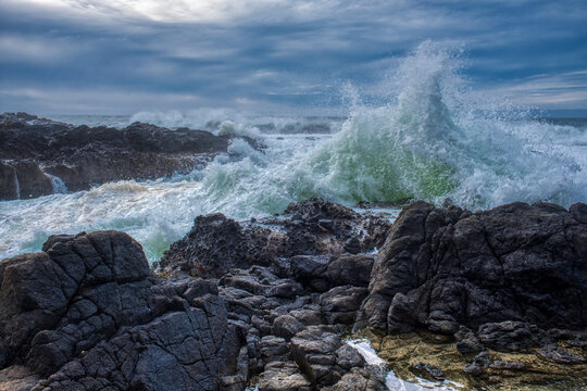Blue Green Ocean wave crashing into rocky beach