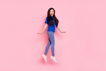Full size photo of happy cheerful nice woman jump up walk good mood isolated on pastel pink color...