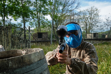Paintball player with gun looking at camera