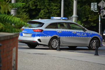 Polska policja drogowa podczas pracy na drodze w mieście. Pojazdy policyjne.  - obrazy, fototapety, plakaty